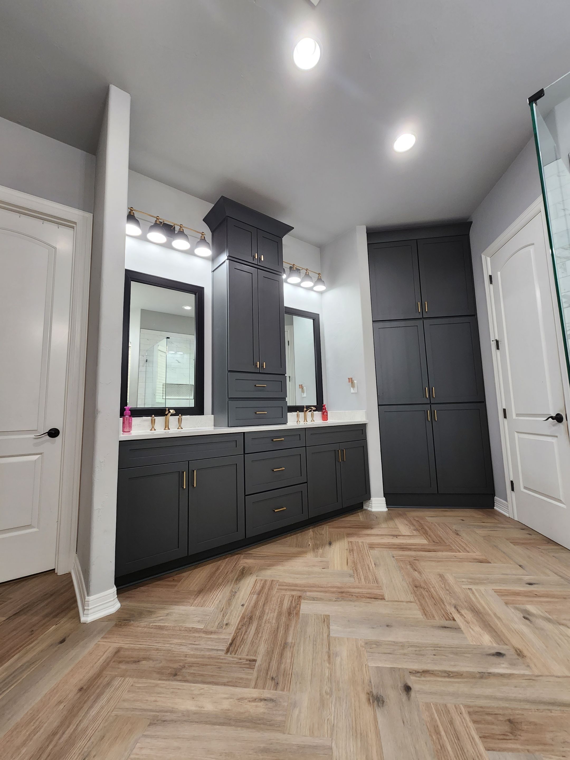 custom vanity in a bathroom remodel in san antonio featuring double sinks, dark cabinets, and extra storage