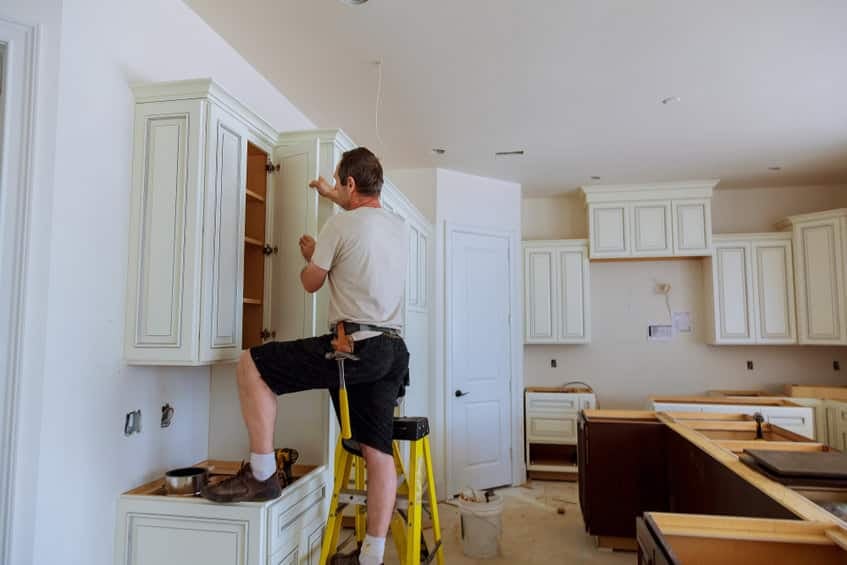Man Installing Cabinets in Kitchen Remodel