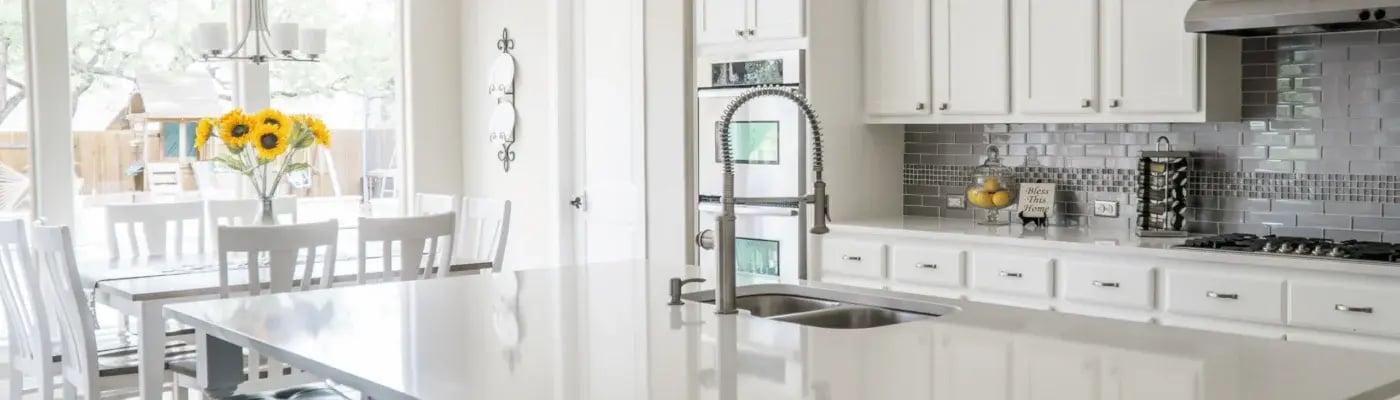 Clean White Kitchen Featuring Vase of Bright Yellow Sunflowers